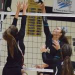 Nikiski junior Kaitlyn Johnson (right) meets Kenais Jaiden Streiff at the net Aug. 25, 2018, at the Shayna Pritchard Memorial tournament at Nikiski High School. (Photo by Joey Klecka/Peninsula Clarion)