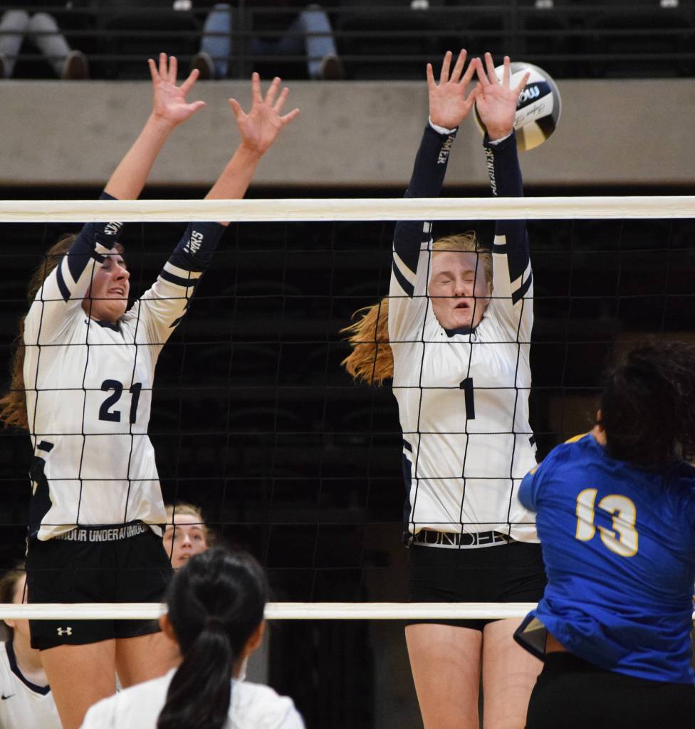 Homers Marina Carroll (21) and Kelli Bishop (1) team up for a block Friday against the Barrow Whalers at the Class 3A state volleyball tournament at the Alaska Airlines Center. (Photo by Joey Klecka/Peninsula Clarion)