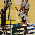 Nikiskis Bethany Carstens (7) pokes a ball toward the Valdez duo of Jade Watts and Kassandra Howard, Saturday in the Class 3A state volleyball championship final against the Buccaneers at the Alaska Airlines Center. (Photo by Joey Klecka/Peninsula Clarion)