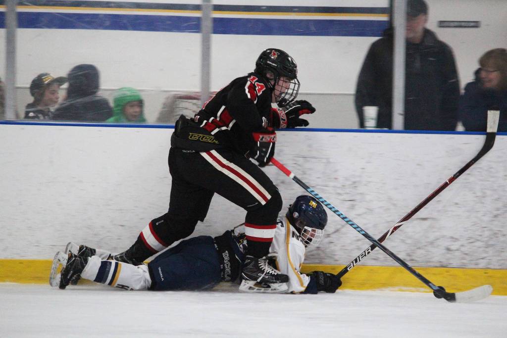 Kenais Miles Marsten steps over Homers Lee Lowe after Lowe fell while both were chasing the puck during a game between the two schools Friday at the End of the Road Shootout at Kevin Bell Arena in Homer. (Photo by Megan Pacer/Homer News)