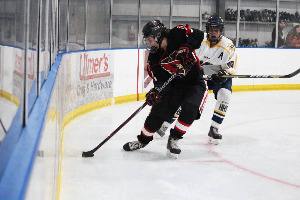 Kenais Logan Dosko grabs the puck out of the corner with Homers Isaiah Nevak on his heels during a game Friday during the End of the Road Shootout at Kevin Bell Arena in Homer. (Photo by Megan Pacer/Homer News)