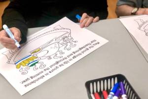 First-, second- and third-grade students from Soldotna Montessori work with residents from Heritage Place to create Thanksgiving art and notes for Kenai Peninsula Food Banks Thanksgiving boxes on Friday in Soldotna. (Photo by Victoria Petersen/Peninsula Clarion)