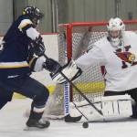 Kenai goaltender Jackson Cross stops a shot from Homer forward Ethan Pitzman (left) Tuesday night at the Kenai Multi Purpose Facility. (Photo by Joey Klecka/Peninsula Clarion)