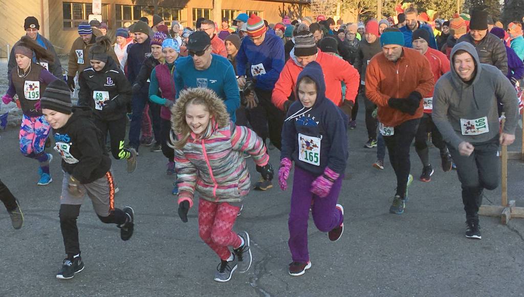 Racers bolt from the start of the Turkey Trot at the Soldotna Regional Sports Complex on Thursday. (Photo by Jeff Helminiak/Peninsula Clarion)