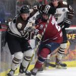 Kenai River Brown Bears defenseman Connor Scahill controls the puck in front of Dylan Abbott of the Fairbanks Ice Dogs and Sutton McDonald of the Brown Bears on Friday, Nov. 23, 2018, at the Soldotna Regional Sports Complex. (Photo by Jeff Helminiak/Peninsula Clarion)