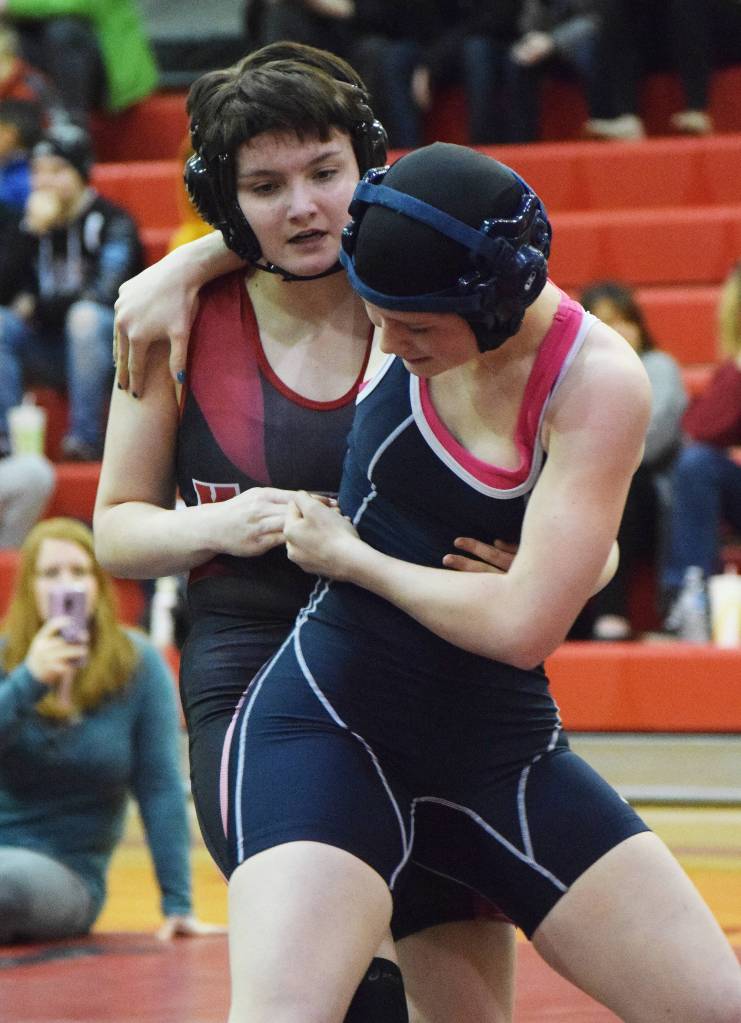 Nikiskis Destiny Martin (right) attempts to wrestle Kenais Olivia Easley to the mat Tuesday night in a dual meet at Kenai Central High School. (Photo by Joey Klecka/Peninsula Clarion)