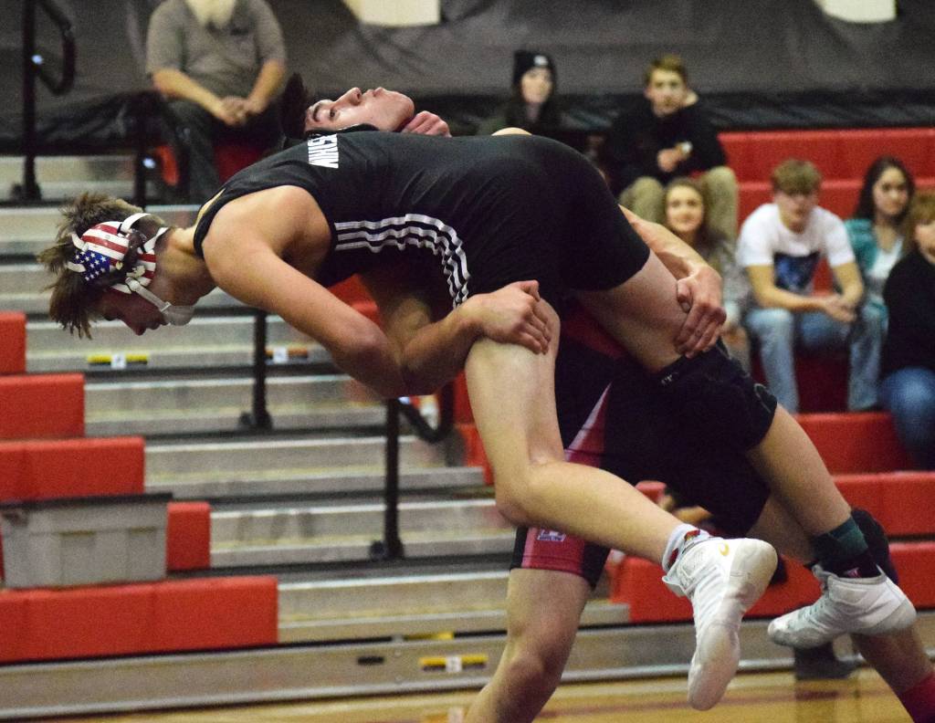 Kenais Brandon Kroto lifts Nikiskis Mason Payne into the air Tuesday night in a dual meet at Kenai Central High School. (Photo by Joey Klecka/Peninsula Clarion)