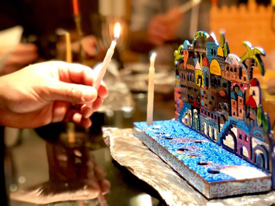 A member lights a candle on their menorah at the Briat Elohim Jewish Congregation Hanukkah party on Dec. 1, 2018, in Kenai, Alaska. (Photo by Victoria Petersen/Peninsula Clarion)                                A member lights a candle on their menorah at the Briat Elohim Jewish Congregation Hanukkah party on Dec. 1, 2018, in Kenai, Alaska. (Photo by Victoria Petersen/Peninsula Clarion)