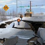In this Friday, Nov. 30 file photo, workers inspect a road that collapsed during an earthquake in Anchorage. The off-ramp connecting Minnesota Drive and Ted Stevens Anchorage International Airport reopened Tuesday, with shoulder work completed Wednesday. (AP Photo/Mike Dinneen, File)