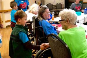 A student in April Kaufmans K-Beach Elementary kindergartner class practices introducing himself to residents at Heritage Place on Friday, Dec. 7, 2018, in Soldotna, Alaska. (Photo by Victoria Petersen/Peninsula Clarion)
