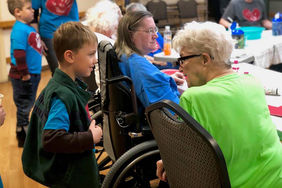 A student in April Kaufmans K-Beach Elementary kindergartner class practices introducing himself to residents at Heritage Place on Friday, Dec. 7, 2018, in Soldotna, Alaska. (Photo by Victoria Petersen/Peninsula Clarion)