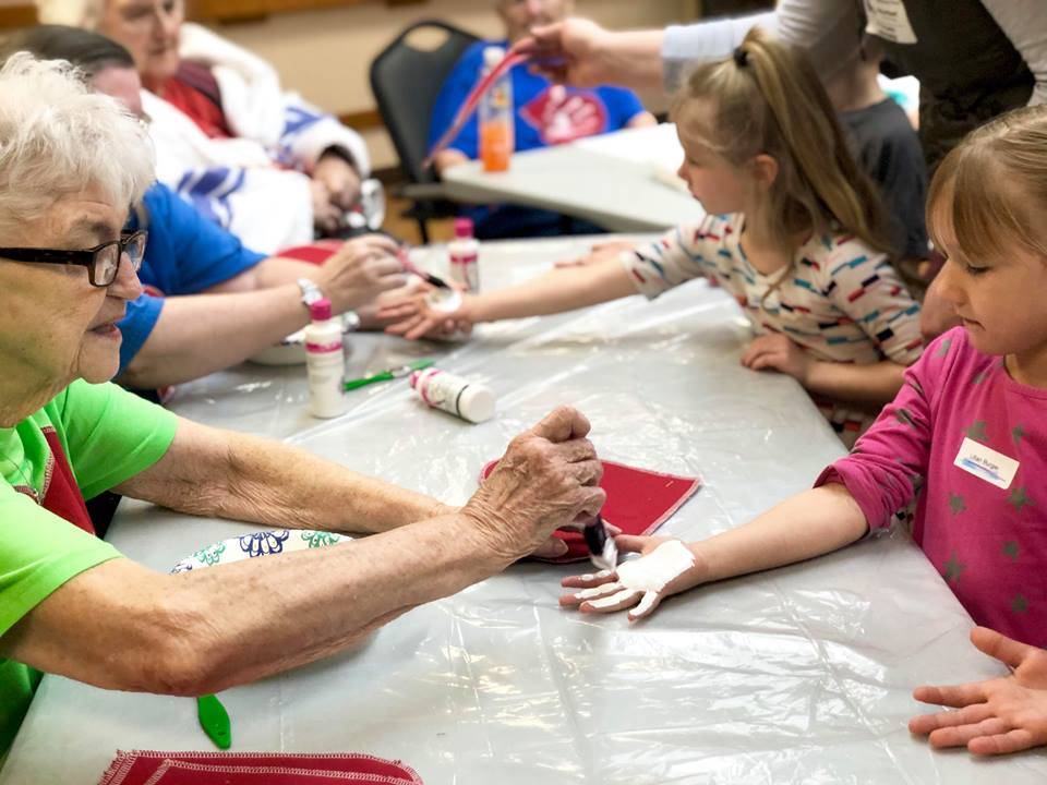 Residents from Heritage Place help kindergartner students make Dignity Mission T-shirts during a visit on Friday, Dec. 7, 2018, in Soldotna, Alaska. (Photo by Victoria Petersen/Peninsula Clarion)
