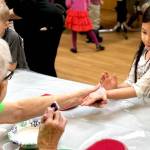 Residents from Heritage Place help kindergarten students make Dignity Mission T-shirts during a visit Friday in Soldotna. (Photo by Victoria Petersen/Peninsula Clarion)                                Residents from Heritage Place help kindergartner students make Dignity Mission T-shirts during a visit on Friday, Dec. 7, 2018, in Soldotna, Alaska. (Photo by Victoria Petersen/Peninsula Clarion)