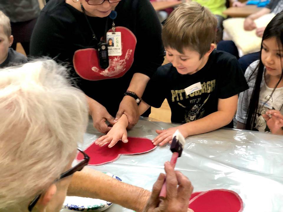 Residents from Heritage Place help kindergartner students make Dignity Mission T-shirts during a visit on Friday, Dec. 7, 2018, in Soldotna, Alaska. (Photo by Victoria Petersen/Peninsula Clarion)