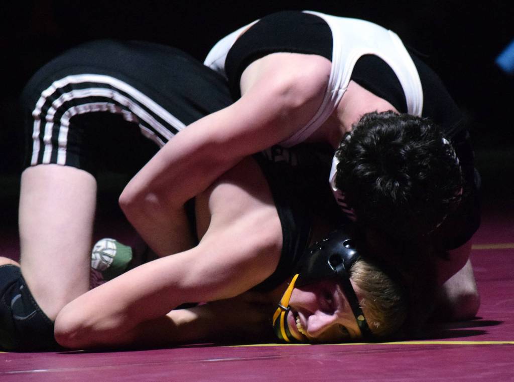 Nikiskis Jaryn Zoda battles against Caleb OHara of ACS Saturday in the 112-pound championship at the Kachemak Conference wrestling tournament at Grace Christian High School in Anchorage. (Photo by Joey Klecka/Peninsula Clarion)