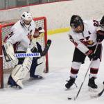 Kenai Central goaltender Carson Koppes keeps an eye on the puck Wednesday night against Juneau-Douglas as teammate Jacob Keels (22) plays keep away at the Kenai Multi-Purpose Facility. (Photo by Joey Klecka/Peninsula Clarion)