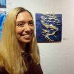 Maria Bernier stands by her painting, Chop, at the First Friday, Dec 7, 2018, opening of Bunnell Street Arts Centers 10x10 show in Homer, Alaska. (Photo by Michael Armstrong/Homer News)