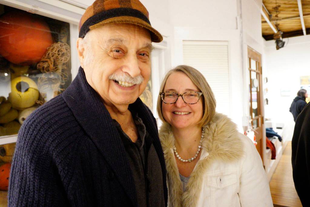 Jack Packer, left, and his daughter, Sharlene Cline, pose for a photo at the First Friday, Dec 7, 2018, opening of Bunnell Street Arts Centers 10x10 show in Homer, Alaska. Both had paintings in the show. (Photo by Michael Armstrong/Homer News)