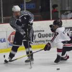 Soldotnas Galen Brantley III keeps the puck away from Kenai Centrals Travis Verkuilen (right) Thursday evening at the Kenai Multi-Purpose Facility. (Photo by Joey Klecka/Peninsula Clarion)