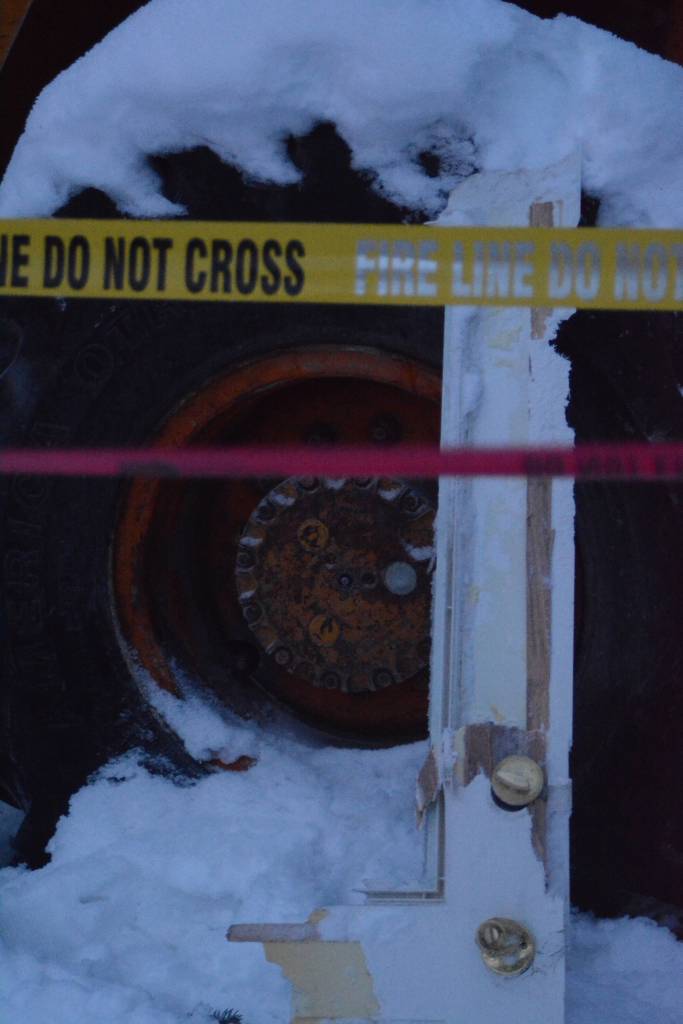 A section of a door from an exploded house lies against a backhoe near Mile 166 Sterling Highway on Friday, Dec. 28, 2018, near Homer, Alaska. The debris field from the explosion spread at least 200 feet in all directions. (Photo by Michael Armstrong/Homer News).
