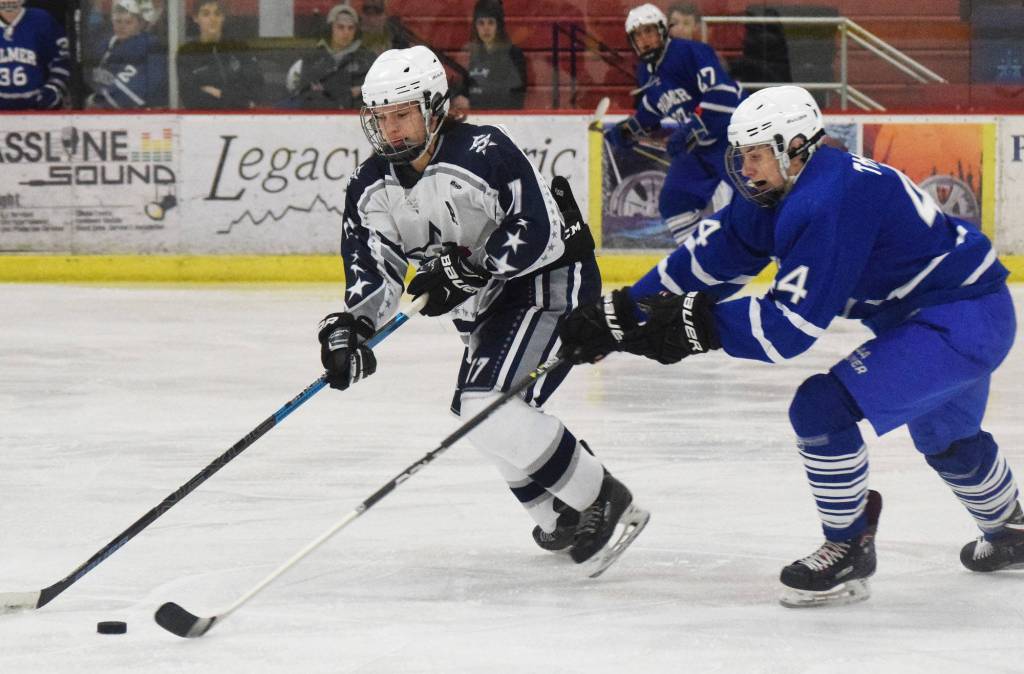 Soldotnas Wyatt Medcoff (left) attempts to clear the puck from Palmers Alex Nelius Thursday at the Soldotna Regional Sports Complex. (Photo by Joey Klecka/Peninsula Clarion)