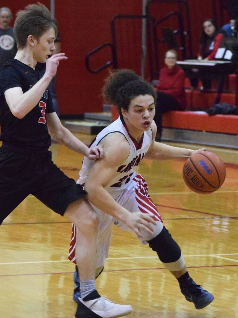 Kenais Tyrone McEnerney (right) drives the lane against Houstons Cody Wyrick Saturday afternoon at Kenai Central High School. (Photo by Joey Klecka/Peninsula Clarion)