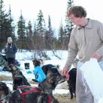 Musher Travis Beals feeds his dog team at a Tustumena 200 Sled Dog Race checkpoint Saturday, Jan. 26, 2019 at McNeil Canyon Elementary School near Homer, Alaska. (Photo by Megan Pacer/Homer News)