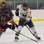 Homers Ethan Pitzman searches for a shot attempt against Glennallens Cassidy Matthews (left) Thursday at the Div. II state hockey championship tournament in Wasilla. (Photo by Joey Klecka/Peninsula Clarion)