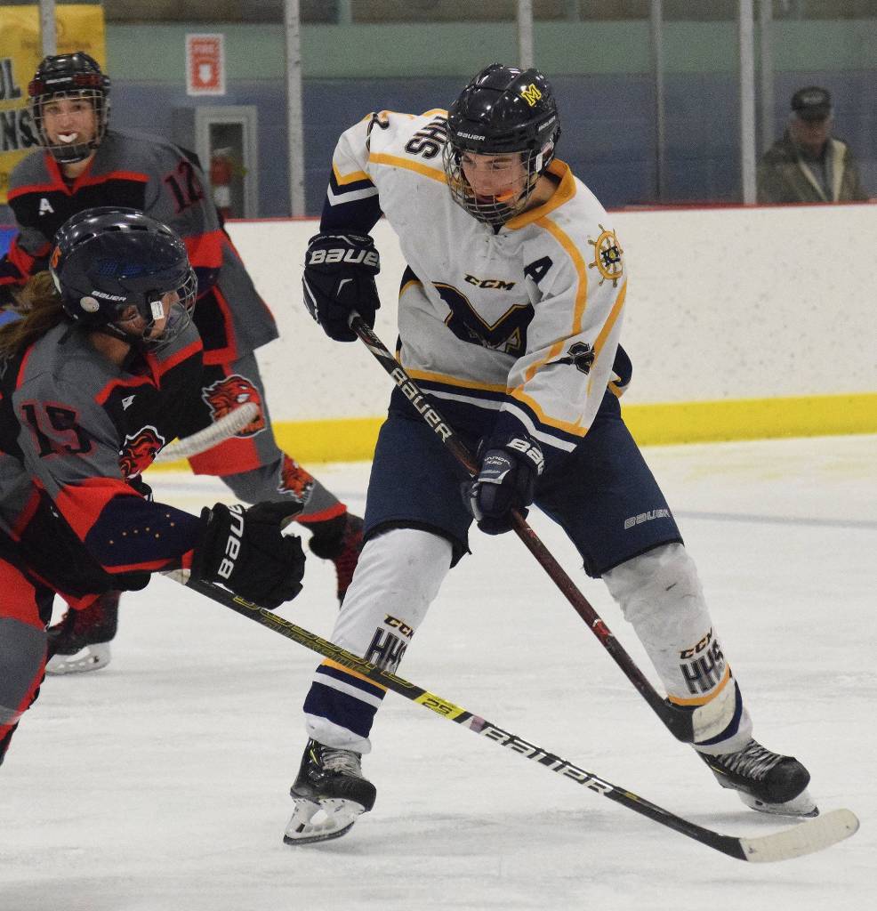 Homers Ethan Pitzman searches for a shot attempt against Glennallens Cassidy Matthews (left) Thursday at the Div. II state hockey championship tournament in Wasilla. (Photo by Joey Klecka/Peninsula Clarion)