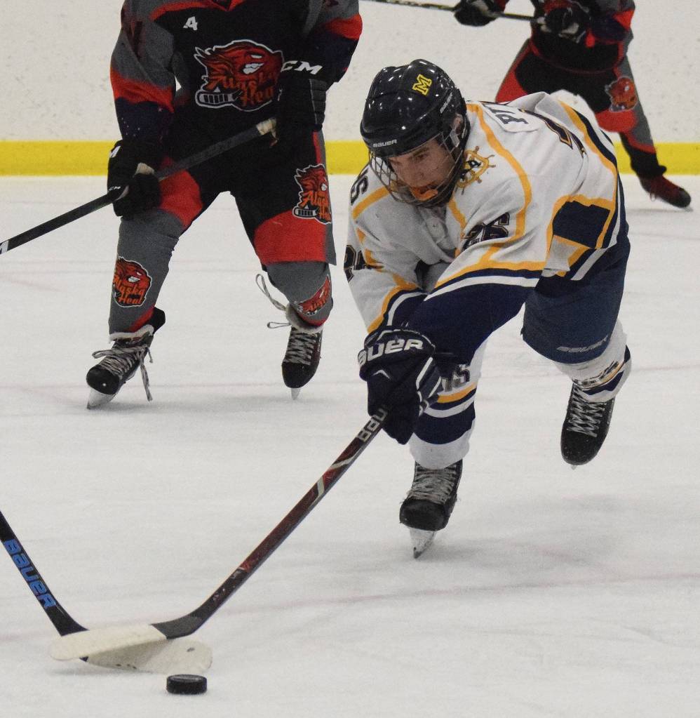 Homers Ethan Pitzman dives for a loose puck Thursday against Glennallen at the Div. II state hockey championship tournament in Wasilla. (Photo by Joey Klecka/Peninsula Clarion)