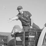 A member of the U.S. Coast Guard tosses candy to children and families lining Pioneer Avenue during the annual Independence Day parade July 4, 2018 in Homer. (Photo by Megan Pacer/Homer News)