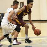 Mt. Edgecumbes Leon Toomer looks for a place to go under pressure from Homers Clayton Beachy during a Thursday, Jan. 10, 2019 game in Homer, Alaska. (Photo by Megan Pacer/Homer News)