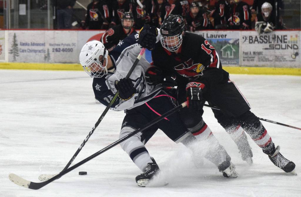 Kenais Aidan Milburn (right) and Soldotnas Dylan Walton fight for the puck Wednesday night in a conference game at the Soldotna Regional Sports Complex. (Photo by Joey Klecka/Peninsula Clarion)