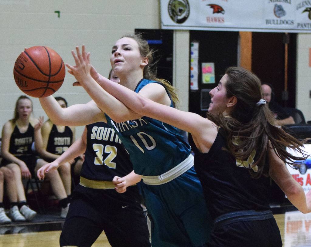 Nikiskis Lillian Carstens drives to the rim by Souths Paige Noble Saturday at the Rus Hitchcock Nikiski Tip Off tournament. (Photo by Joey Klecka/Peninsula Clarion)