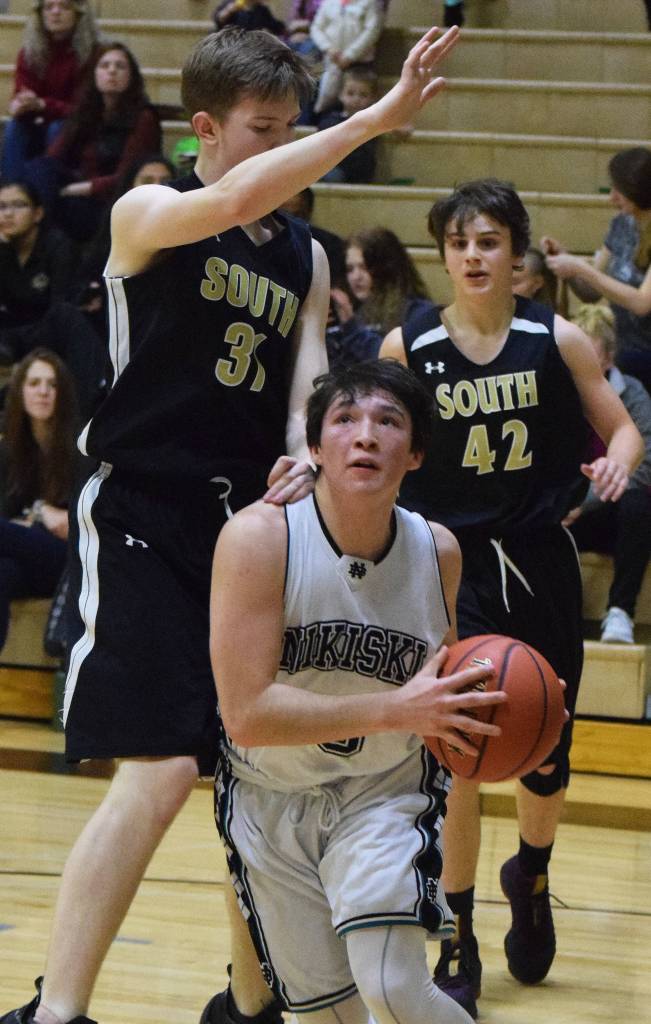 Nikiskis Michael Mysing makes a move to the rim by Souths Shane Wardhaugh (left) Saturday at the Rus Hitchcock Nikiski Tip Off tournament. (Photo by Joey Klecka/Peninsula Clarion)