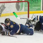 Juneau-Douglas Dalton Hoy crashes into the net as he competes against Homers Tucker Weston, center, and goalie Hunter Warren at Treadwell Arena on Friday, Jan. 18, 2019. JDHS won 4-3 in overtime. (Michael Penn | Juneau Empire)