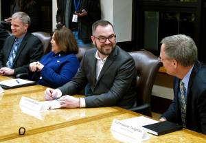 In this Jan. 8 file photo, Alaska Department of Administration Commissioner Jonathan Quick, second from right, speaks with Revenue Commissioner Bruce Tangeman, right, before the start of a cabinet meeting at the state Capitol in Juneau, Alaska. (AP Photo/Becky Bohrer, File)