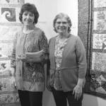 Patrice Krant, left, and Janet Bacher, right, stand by their quilts in the 9 Women / 9 Quilts show that opened last Friday, Feb. 1, 2019, at the Homer Council on the Arts, in Homer, Alaska. (Photo by Michael Armstrong/Homer News)