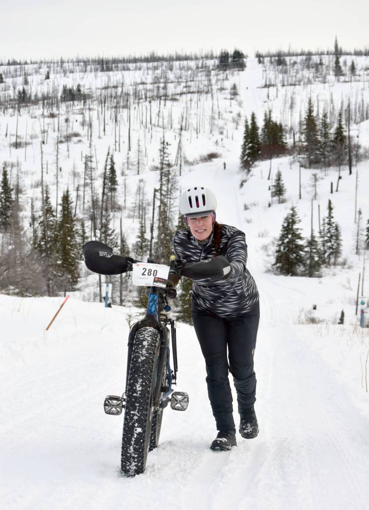 Simone Owens pushes her bike up a hill during Fat Freddies Bike Race and Ramble on Saturday, Feb. 9, 2019, in the Caribou Hills near Freddies Roadhouse. (Photo by Jeff Helminiak/Peninsula Clarion)