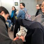 Jeff Chen, left, affixes a Defend the Sacred logo to Su Chons jacket ahead of a Bureau of Land Management hearing Monday, Feb. 11, 2019, in Anchorage, Alaska. The two Anchorage residents planned to oppose drilling as the federal agency accepted public comments on a draft environmental review on drilling within the coastal plain of the Arctic National Wildlife Refuge. (AP Photo/Mark Thiessen)