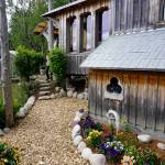 Drifwood and rock is used to line the gardens at the Jeff and Ranja Dean farm. It was one of five gardens featured in the 2018 Homer Garden Tour. (Photo by Michael Armstrong/Homer News)