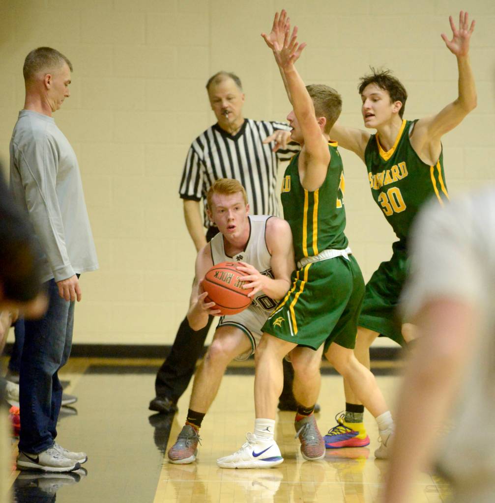Nikiskis Jace Kornstad is trapped by Sewards Trey Ingalls and Bjorn Nillson on Friday, Feb. 15, 2019, at Nikiski High School. (Photo by Jeff Helminiak/Peninsula Clarion)