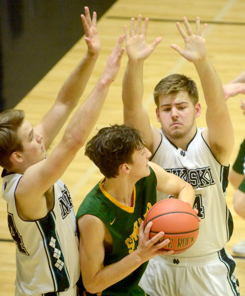 Nikiskis Michael Eiter and Seth DeSiena trap Sewards Bjorn Nillson on Friday, Feb. 15, 2019, at Nikiski High School. (Photo by Jeff Helminiak/Peninsula Clarion)