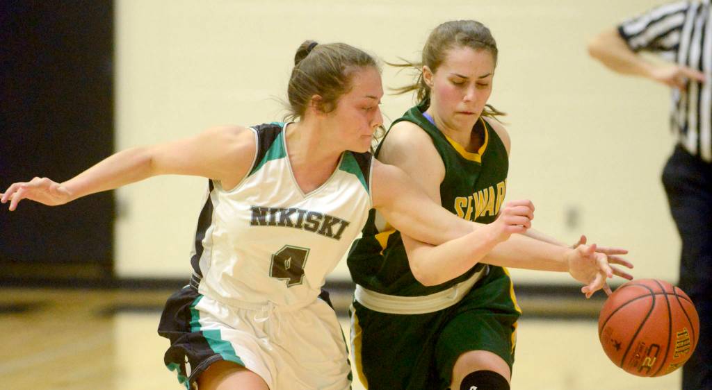 Nikiskis Emma Wik reaches in on Sewards Ashley Jackson on Friday, Feb. 15, 2019, at Nikiski High School. (Photo by Jeff Helminiak/Peninsula Clarion)