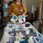 Weaver Lily Hope lays out woven squares for a new project called the Giving Strength Robe on Friday, Feb. 15, 2019. (Michael Penn | Juneau Empire)