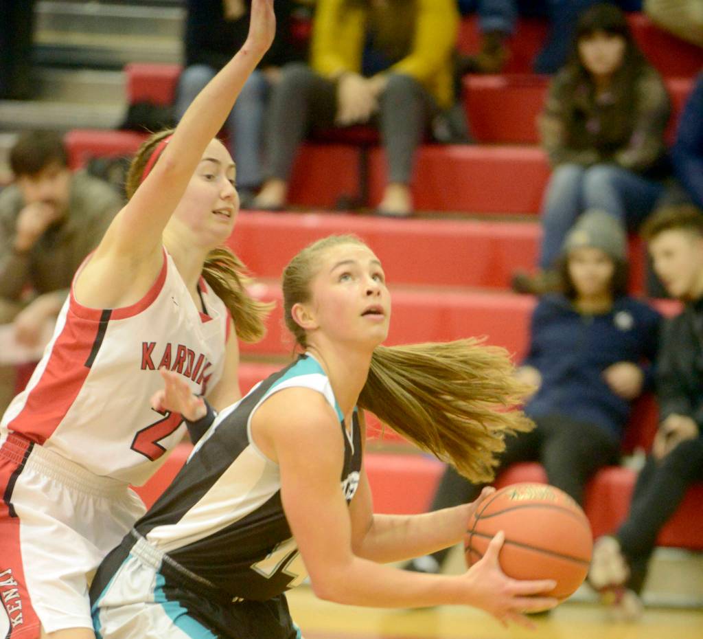 Nikiskis Kaitlyn Johnson powers to the basket against Kenai Centrals Jaycie Calvert on Tuesday, Feb. 19, 2019, at Kenai Central High School. (Photo by Jeff Helminiak/Peninsula Clarion)