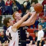 Kenai Centrals Logan Baker fouls Nikiskis Jace Kornstad on Tuesday, Feb. 19, 2019, at Kenai Central High School. (Photo by Jeff Helminiak/Peninsula Clarion)