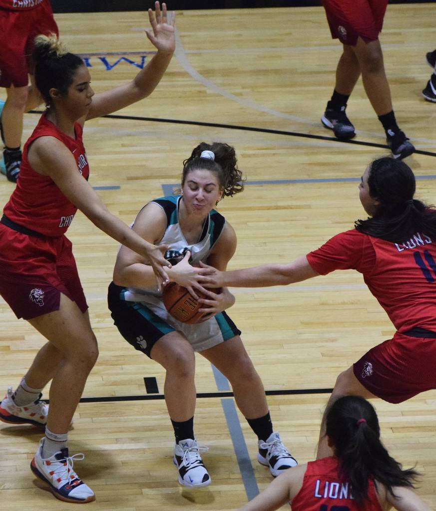 Nikiskis Kelsey Clark (center) becomes trapped in the paint by Anchorages Adara Powell (left) and Destiny Reimers Friday in a Southcentral Conference contest at Nikiski High School. (Photo by Joey Klecka/Peninsula Clarion)