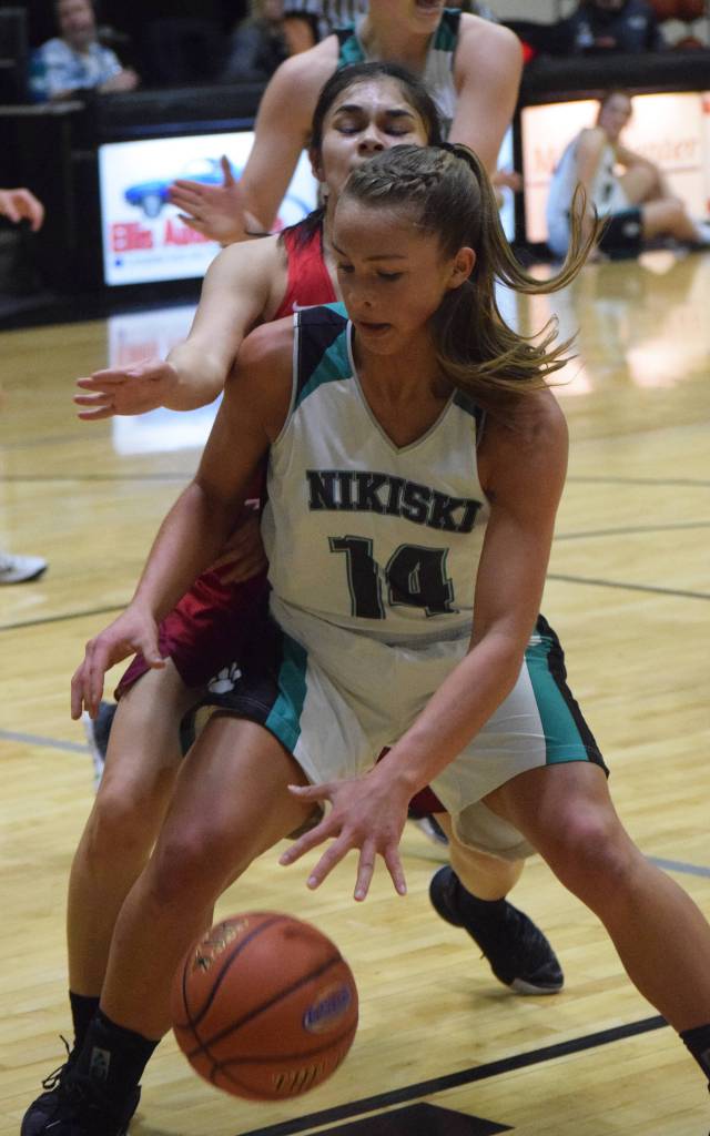 Nikiskis Kaitlyn Johnson (14) works for space against Anchorages Jessie Davis Friday in a Southcentral Conference contest at Nikiski High School. (Photo by Joey Klecka/Peninsula Clarion)