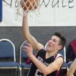 Nikolaevsks Justin Trail drives past Cook Inlet Academys James Anderson on Friday, Dec. 14, 2018, at Cook Inlet Academy in Soldotna. (Photo by Jeff Helminiak/Peninsula Clarion)
